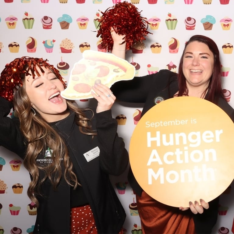 Employees from Anchorage Chamber of Commerce playing with the photo booth during Business After Hours' Annual Hunger Action Month event